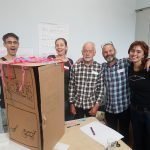 5 people face the camera and smile.